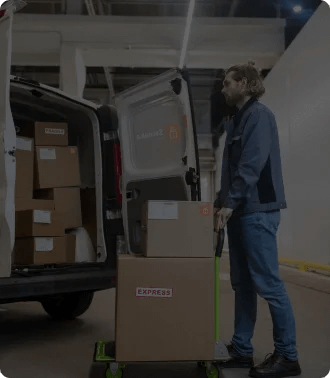 Driver loading a truck and using Sweaka Driver app, ensuring efficient tracking and satisfaction in warehouse operations.